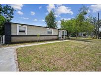 Charming home featuring a spacious front lawn and a covered entrance, creating a welcoming curb appeal at 1711 E Sewaha St, Tampa, FL 33612