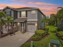 Charming two-story home featuring a stone-accented facade, attached garage, and beautiful landscaping at 8661 Daydream St, Sarasota, FL 34238