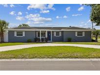 Charming single story home featuring a manicured lawn, neutral paint, blue front door, and white trimmed windows at 1035 S Duncan Ave, Clearwater, FL 33756