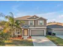 Charming two-story home boasts a well-maintained lawn and a two-car garage at 8506 Hunters Fork Loop, Ruskin, FL 33573