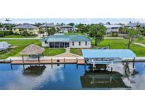 Waterfront home with lush landscaping, private dock, tiki hut and boat lift at 24277 Treasure Island Blvd, Punta Gorda, FL 33955