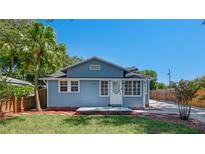 Charming home featuring a well-manicured lawn, palm tree, and a light blue exterior paint at 6020 Illinois Ave, New Port Richey, FL 34653