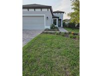 Charming single Gathering home featuring a well-manicured lawn and paver walkway at 12513 Oak Hill Way, Parrish, FL 34219