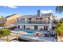 Beautiful two-story home with a backyard pool, canal access, and a waterfront patio with outdoor seating at 328 6Th Ave, Indian Rocks Beach, FL 33785