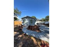 Charming, light blue single-story home featuring a well-maintained front yard and convenient carport at 5015 N 29Th St, Tampa, FL 33610