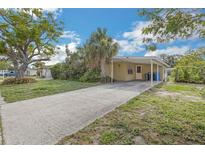 Charming single-story home with a covered carport, driveway, mature landscaping and a welcoming facade at 5101 Town N Country Blvd, Tampa, FL 33615