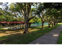 Community with covered picnic area and tennis courts shaded by mature trees at 1122 Montrose Pl # 1713, Dunedin, FL 34698