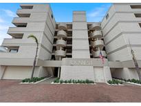 Contemporary condo building featuring private balconies, well-kept landscaping, and a view of the parking area at 19700 Gulf Blvd # 204, Indian Shores, FL 33785