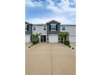 Charming townhome featuring a two-car garage, modern facade and manicured landscaping at 2913 Suncoast Plains Dr, Odessa, FL 33556