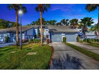 Inviting two-story townhome features a private driveway and a well-maintained front yard with lush landscaping at 4239 Brentwood Park Cir, Tampa, FL 33624