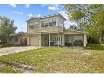 Two-story home featuring a single-car garage and covered front porch at 6310 Cecelia Dr, New Port Richey, FL 34653
