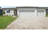 Charming home featuring a paved driveway and attached two-car garage at 1775 Draughton Dr, Zephyrhills, FL 33541