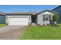 Charming single-Gathering home features a well-manicured lawn and a brick paved driveway at 1817 Draughton Dr, Zephyrhills, FL 33541