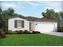 Charming single-story home with a manicured lawn, colorful flowerbeds, and attached two car garage at 1817 Draughton Dr, Zephyrhills, FL 33541