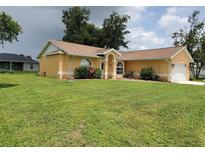 Charming single-story home with a well-manicured lawn and beautiful landscaping at 1835 Rival Ter, North Port, FL 34286