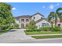 Elegant two-story home with lush landscaping, paver driveway, and stone accents at 5531 Arnie Loop, Bradenton, FL 34211