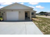 Charming single-story home featuring an attached garage, covered entry and a well-maintained lawn at 12800 Kellywood Cir, Hudson, FL 34669