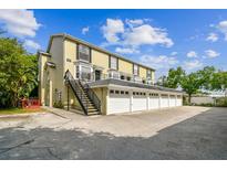 Exterior shot of a three-story townhome with individual garages and outdoor stairwell at 609 S Glen Ave # E, Tampa, FL 33609