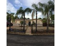 Charming single-story home with mature palm trees and a fenced front yard at 3680 Whiting Se Dr, St Petersburg, FL 33705