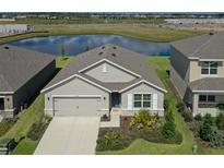 Charming single-Gathering home featuring a two-car garage, complemented by lush landscaping, and a serene water view at 17127 Harvest Moon Way, Bradenton, FL 34211