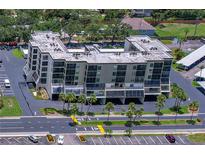 Aerial view of a light beige condominium complex, highlighting the building's architecture and well-maintained surroundings at 9860 62Nd N Ter # 1047, St Petersburg, FL 33708
