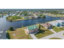 Waterfront home with a green roof, canal access, and well-maintained landscaping at 15340 Alsask Cir, Port Charlotte, FL 33981