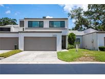 Stylish two-story home featuring a well-kept lawn, front yard landscaping, and an attached two-car garage at 4203 Fairway Run, Tampa, FL 33618