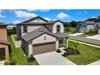 Beautiful two-story home with a two car garage and manicured lawn with lush landscaping at 9937 Aqua Miles Path, Wesley Chapel, FL 33545