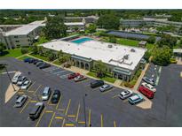 Aerial view of the community center, pool, parking lot, and solar panel array at this condo complex at 2257 World Parkway W Blvd # 61, Clearwater, FL 33763