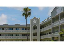 Multi-story condo building with balconies, manicured landscaping, and a prominent palm tree at 2257 World Parkway W Blvd # 61, Clearwater, FL 33763
