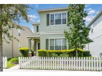 Charming two-story home with a picket fence and well-maintained landscaping in a suburban neighborhood at 11314 Grand Park Ave, Riverview, FL 33578