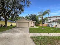 Charming single-story home with a well-maintained lawn and attached two-car garage at 9855 Morris Glen Way, Temple Terrace, FL 33637
