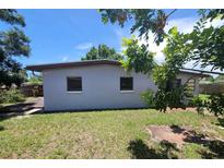 Exterior view of backyard featuring grass and the rear of the house at 8035 Robin Rd, Seminole, FL 33777