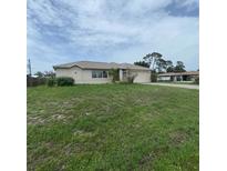 Charming single-story home with a well-maintained lawn and attached two car garage at 1140 Belmar Ave, Port Charlotte, FL 33948