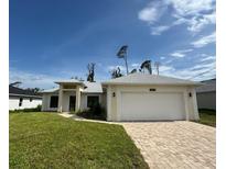 This beautiful single Gathering home features a 2-car garage, well manicured lawn and a concrete driveway at 16475 Hillsborough Blvd, Port Charlotte, FL 33954