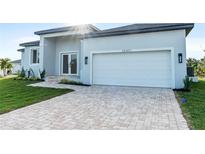 Charming single Gathering home showcasing manicured lawn and brick driveway at 10071 Kingsville Dr, Port Charlotte, FL 33981