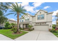 Stunning two-story home boasts a well-manicured lawn and beautiful landscaping including a mature palm tree at 10720 Breaking Rocks Dr, Tampa, FL 33647