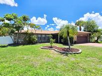 Charming home showcasing stone accents, lush landscaping, and a well-manicured lawn at 1302 Georgetowne Cir, Sarasota, FL 34232