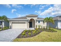 Charming single-story home with manicured landscaping, inviting entrance, paved driveway, and attached two-car garage at 9581 Vibrant Lane, Venice, FL 34292