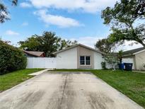 Charming single-story home with a white brick exterior, concrete driveway, and well-maintained lawn at 10344 Rosemount Dr, Tampa, FL 33624