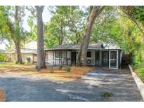 Charming single-story home with mature trees and a cozy, screened-in porch area at 709 1St Ne Ave, Largo, FL 33770