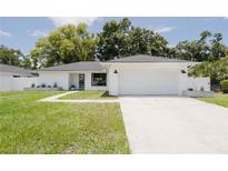 Charming home featuring a minimalist design, a wide driveway, and a well-manicured lawn at 3920 Basswood Dr, Sarasota, FL 34232