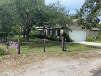 Charming single-story home with a well-maintained lawn, mature trees, and a 
