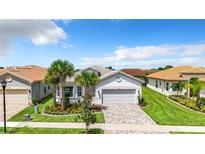 Beautiful single-story home featuring a paved driveway, tropical landscaping, and an attached two-car garage at 15503 Corona Del Mar Dr, Wimauma, FL 33598