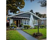 Charming single-story home with a well-manicured lawn, a brick chimney, and a walkway leading to the front door at 132 17Th N Ave, St Petersburg, FL 33704