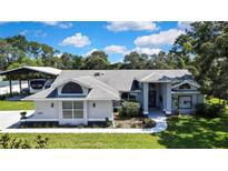 Charming single-Gathering home with manicured lawn, mature trees, and covered parking at 13295 Don Loop, Spring Hill, FL 34609