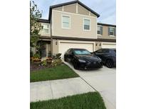 Inviting two-story townhouse with attached garage, landscaped yard, and well-manicured lawn at 10302 Lavender Aster Trl, San Antonio, FL 33576