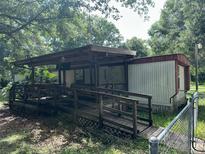 Quaint home with covered entry ramp and mature trees at 26627 Brahma Dr, Wesley Chapel, FL 33544