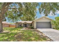 Charming single-story home featuring a manicured lawn and an attached two-car garage at 837 Greenbelt Cir, Brandon, FL 33510
