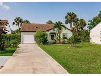 Charming single-story home with well-manicured lawn, mature landscaping, and a convenient attached garage at 1244 E Corktree Cir, Port Charlotte, FL 33952